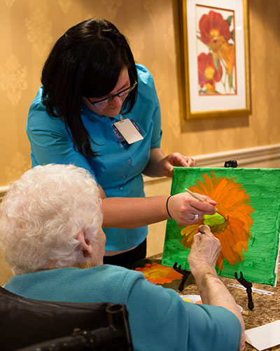caregiver helping senior wopman paint