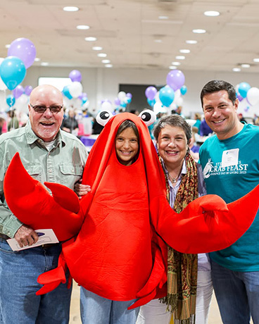 young girl in a grab costume posing for the camera with her family